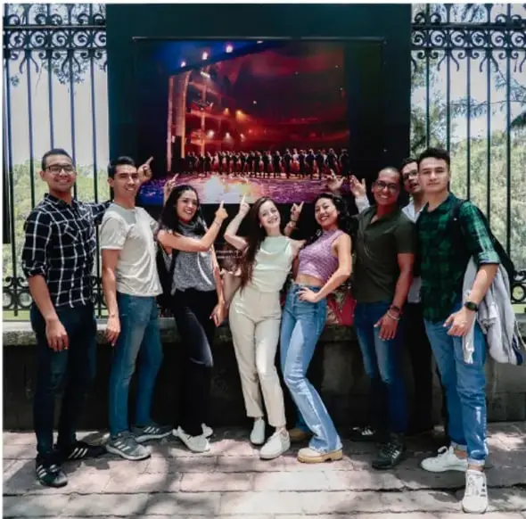 Grupo de jóvenes posando frente a una pantalla grande, representando la diversidad de identidades juveniles.
