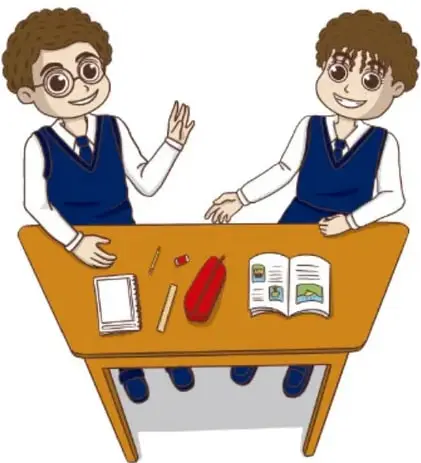 Niño nuevo (Emi) detrás del escritorio de la maestra junto a otro niño de uniforme; hay cuadernos, lápiz y un rojo estuche sobre la mesa.