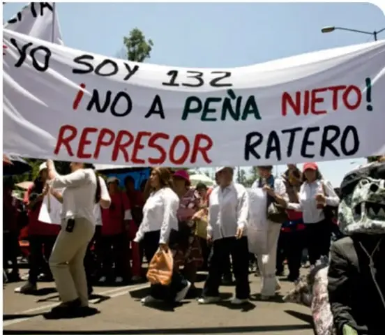 Fotografía de una marcha con una manta que dice 'YO SOY 132 ¡NO A PEÑA NIETO! REPRESOR RATERO'.