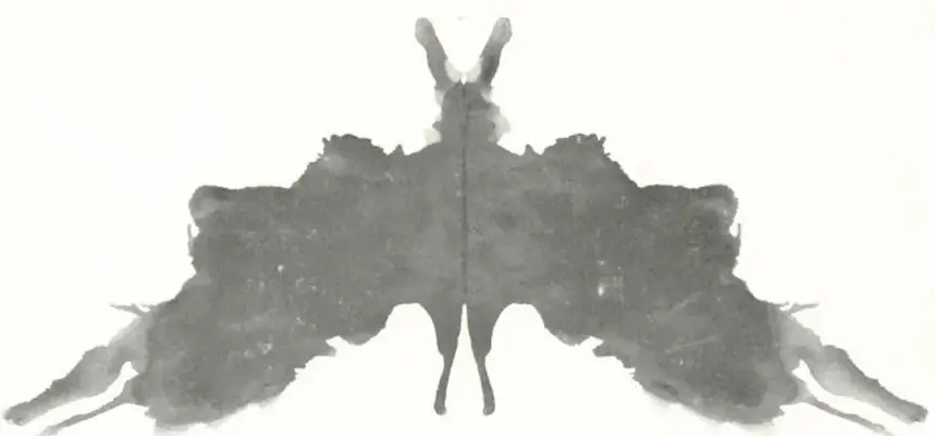 Mancha de tinta simétrica en gris, parecida a una mariposa o a un animal con orejas: imagen tipo prueba de Rorschach.