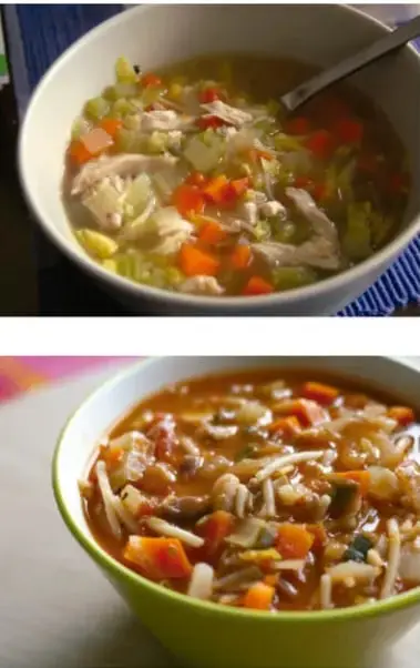 Tazón blanco con sopa de verduras y pollo, con una cuchara de metal.