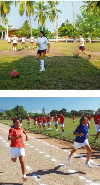 Fotografía de jóvenes jugando fútbol en una cancha de pasto con palmeras al fondo.