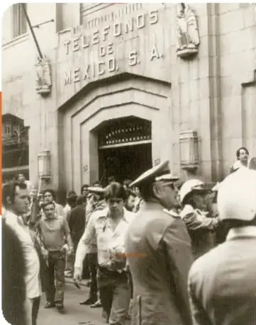Fachada del edificio de Teléfonos de México con personas afuera.