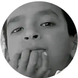 Fotografía en blanco y negro del rostro de un niño pensativo con la mano en la boca.