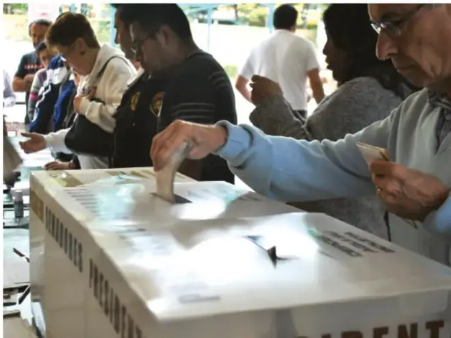 Fotografía de ciudadanos colocando su boleta de votación en una urna electoral, representando la participación democrática en México.