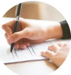Fotografía de una mano escribiendo con pluma en una libreta, representando el registro de datos.