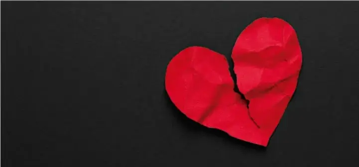 Fotografía de un corazón de papel rojo partido en dos sobre un fondo negro, símbolo visual posiblemente vinculado a la expresión figurada del lenguaje emocional.