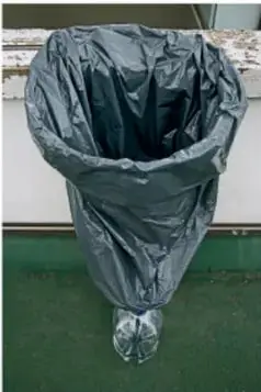 Fotografía de una bolsa de plástico negra colocada como recolector de agua dentro de un recipiente.