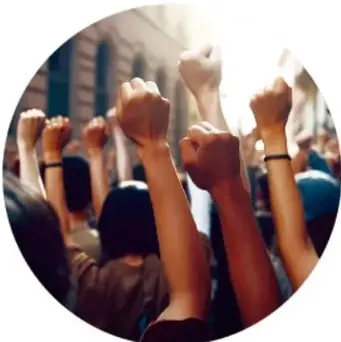 Manos levantadas con puños cerrados en señal de protesta y unión, símbolo de la lucha colectiva por los derechos.