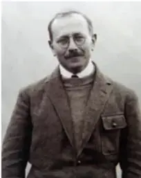 Fotografía en blanco y negro de Marc Bloch, historiador francés, de pie con saco y lentes.