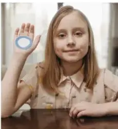 Niña con un anillo/objeto en la mano, ilustra diabetes infantil.