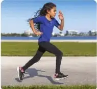 Fotografía de una niña corriendo en una pista atlética.