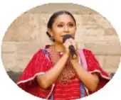 Mujer indígena con traje tradicional hablando, ilustra el prejuicio lingüístico.