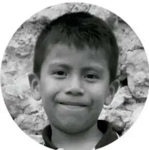Fotografía en blanco y negro de un niño sonriendo de frente.