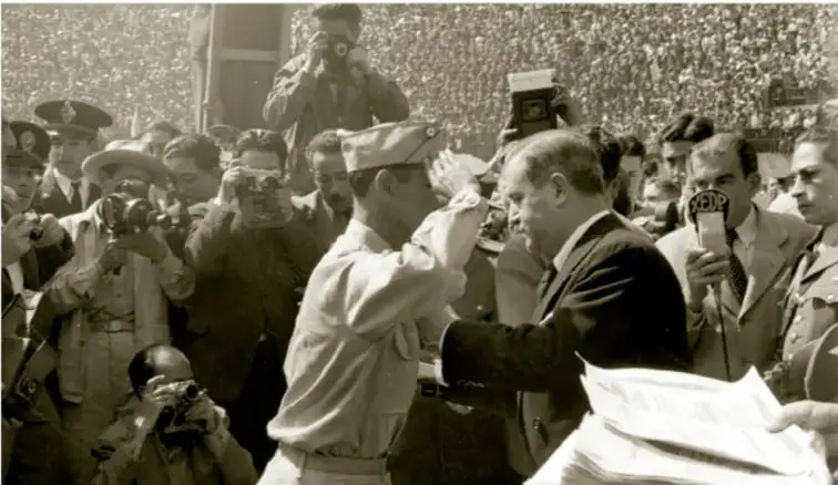 Fotografía en blanco y negro de una multitud y personajes políticos, probablemente durante la campaña o toma de posesión de Manuel Ávila Camacho.