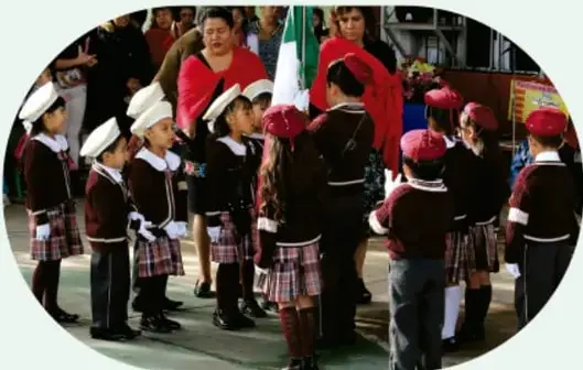 Niños y niñas con uniforme escolar formados en un patio.