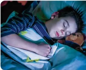 Niño durmiendo en su cama.