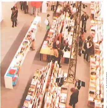 Vista de una feria con puestos de libros y visitantes.