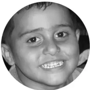 Fotografía en blanco y negro de un niño sonriente, en formato circular, que acompaña la sección de preparación de la feria.