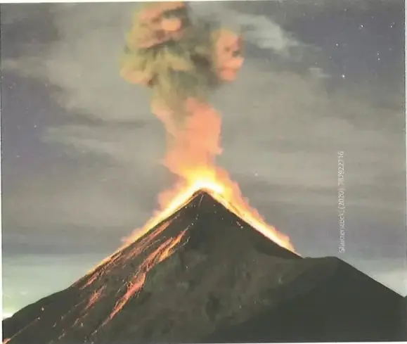 Pequeña fotografía en la esquina superior derecha de la página mostrando rocas volcánicas o lava solidificada de color oscuro rojizo/naranja. Ilustra los productos volcánicos descritos en el texto (lavas y/o piroclastos). La imagen complementa visualmente el contenido textual sobre tipos de lavas.