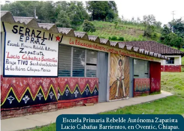 Fachada de la Escuela Primaria Rebelde Autónoma Zapatista Lucio Cabañas Barrientos, en Oventic, Chiapas, con murales y letreros.