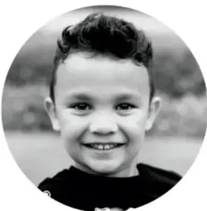 Fotografía circular en blanco y negro de un niño sonriente.