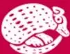 Emblema circular con un animal (armadillo estilizado) sobre fondo magenta.