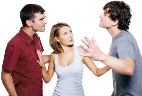 Fotografía de tres jóvenes: dos hombres en actitud de discusión y una mujer intermedia con las manos levantadas intentando separarlos, representando un conflicto y la necesidad de mediación.