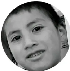 Fotografía circular en blanco y negro de la cara de una niña que sonríe.