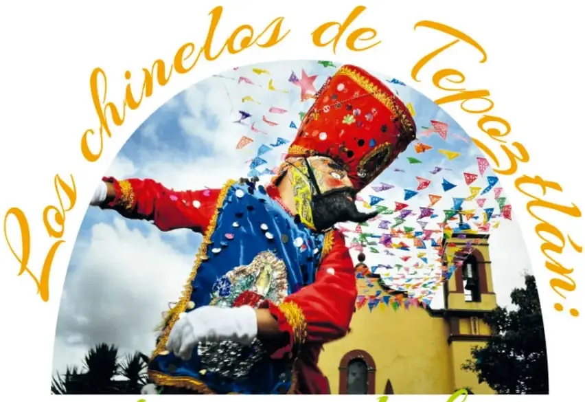 Fotografía de un chinelo danzando con su traje vistoso, máscara, sombrero alto y papeles picados, con una iglesia amarilla al fondo.