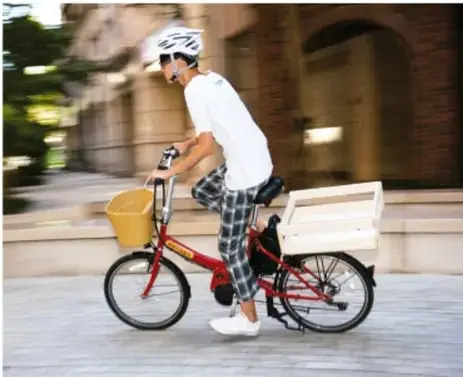 Fotografía de un ciclista con casco avanzando por una calle, usada para ilustrar la rapidez de $5\,\text{m/s}$.