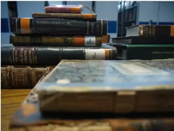 Pila de libros antiguos y encuadernados sobre una mesa, símbolo de las fuentes históricas.