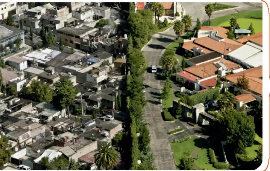 Vista aérea de una ciudad con contraste entre casas grandes con jardines y viviendas humildes y apiñadas.