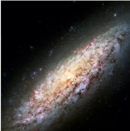 Fotografía de una galaxia espiral con su núcleo brillante y brazos espirales iluminados sobre un fondo de estrellas.