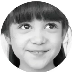 Fotografía de una niña sonriente con fleco.