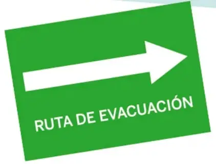 Dos señales: un letrero celeste con figuras de hombre y mujer y la palabra BAÑO, y un letrero verde con una flecha blanca y el texto RUTA DE EVACUACIÓN.