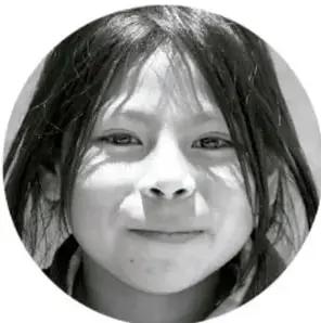Fotografía circular en blanco y negro de una niña sonriendo.