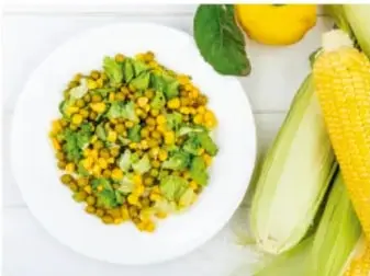 Fotografía de un plato con granos de maíz y elotes.