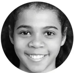 Fotografía en blanco y negro de una niña sonriente dentro de un círculo.