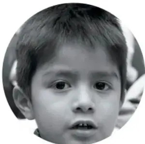 Retrato circular de un niño pequeño con cabello corto y mirada seria.
