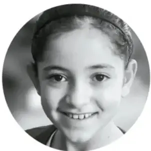 Fotografía circular en blanco y negro de una niña sonriendo con diadema.