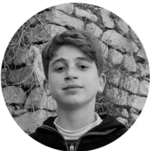 Fotografía de un niño de espaldas a un muro de piedra, representando a la comunidad escolar.