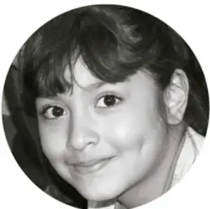 Fotografía circular en blanco y negro del rostro sonriente de una niña.
