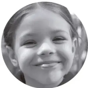 Fotografía de una niña sonriente con cabello recogido.