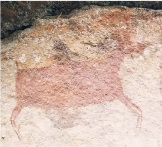 Fotografía de una pintura rupestre rojiza sobre pared rocosa: se distingue la figura de un gran animal cuadrúpedo (tipo venado o cérvido).