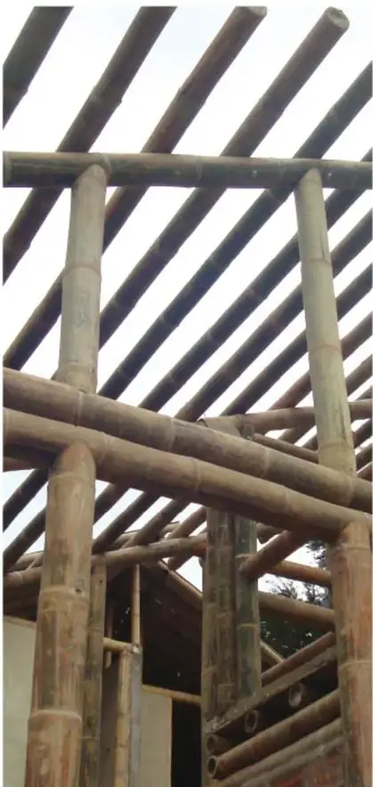 Fotografía de una estructura de bambú con columnas y vigas cruzadas, ejemplo real de construcción con tubos naturales.