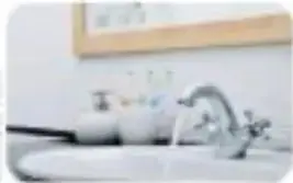 Fotografía de un niño usando agua en un lavabo mientras se cepilla los dientes.