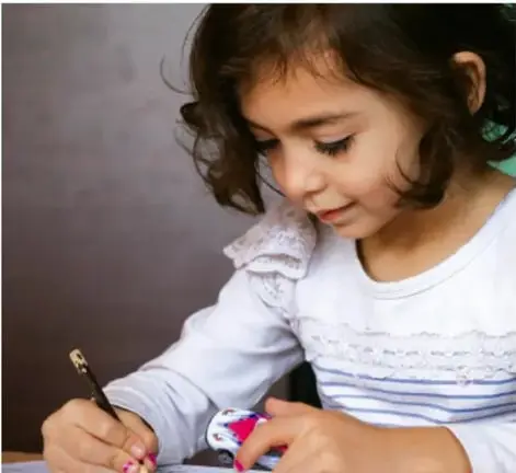 Niña escribiendo en una hoja con un lápiz, ilustra la actividad de redactar la carta.
