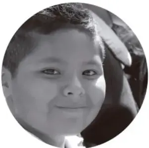 Fotografía de un niño sonriente, estudiante de primaria.