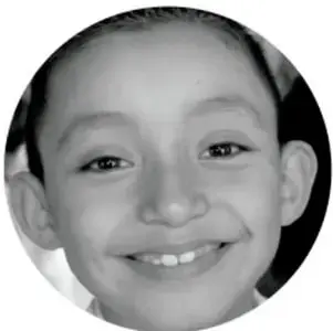 Retrato circular en escala de grises de una niña sonriente, probablemente Maya, que protagoniza el escenario.